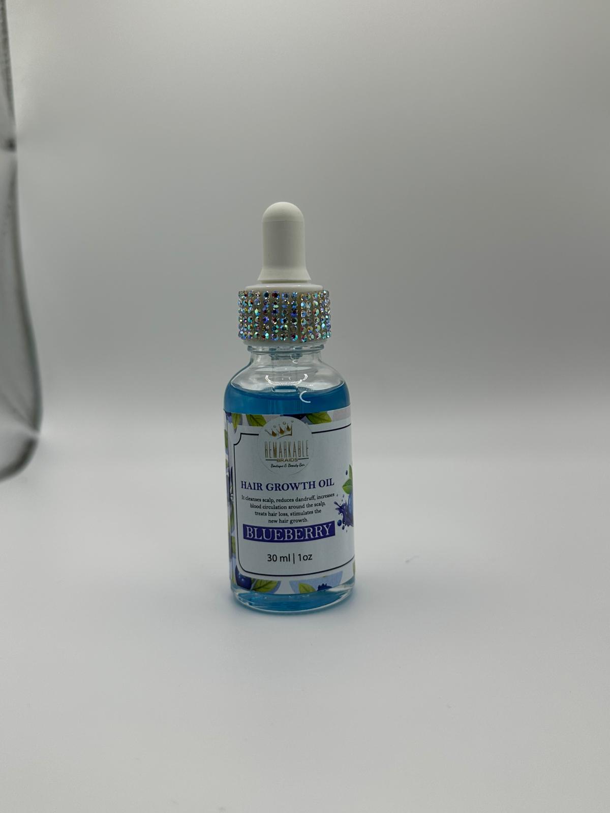 Bottle of hair growth oil with blue liquid on a white background