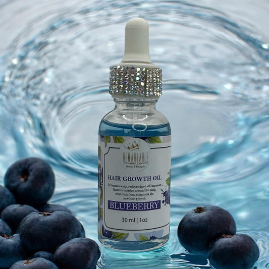 Bottle of hair growth oil with blueberries on a swirling water background