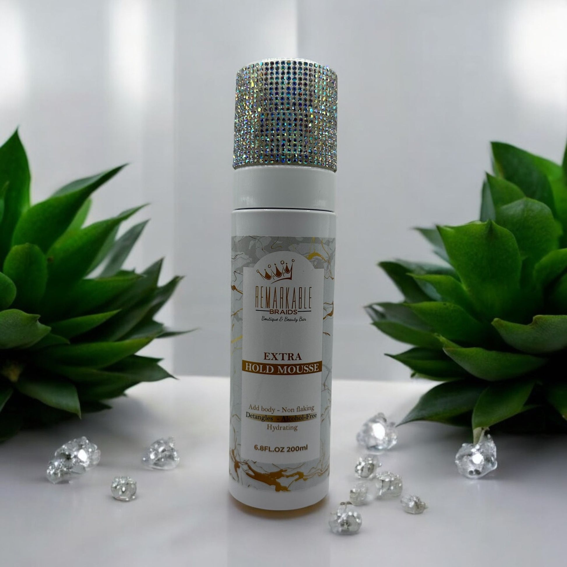 Remarkable Extra Hold Hair Mousse displayed with decorative top on a white surface with green plants