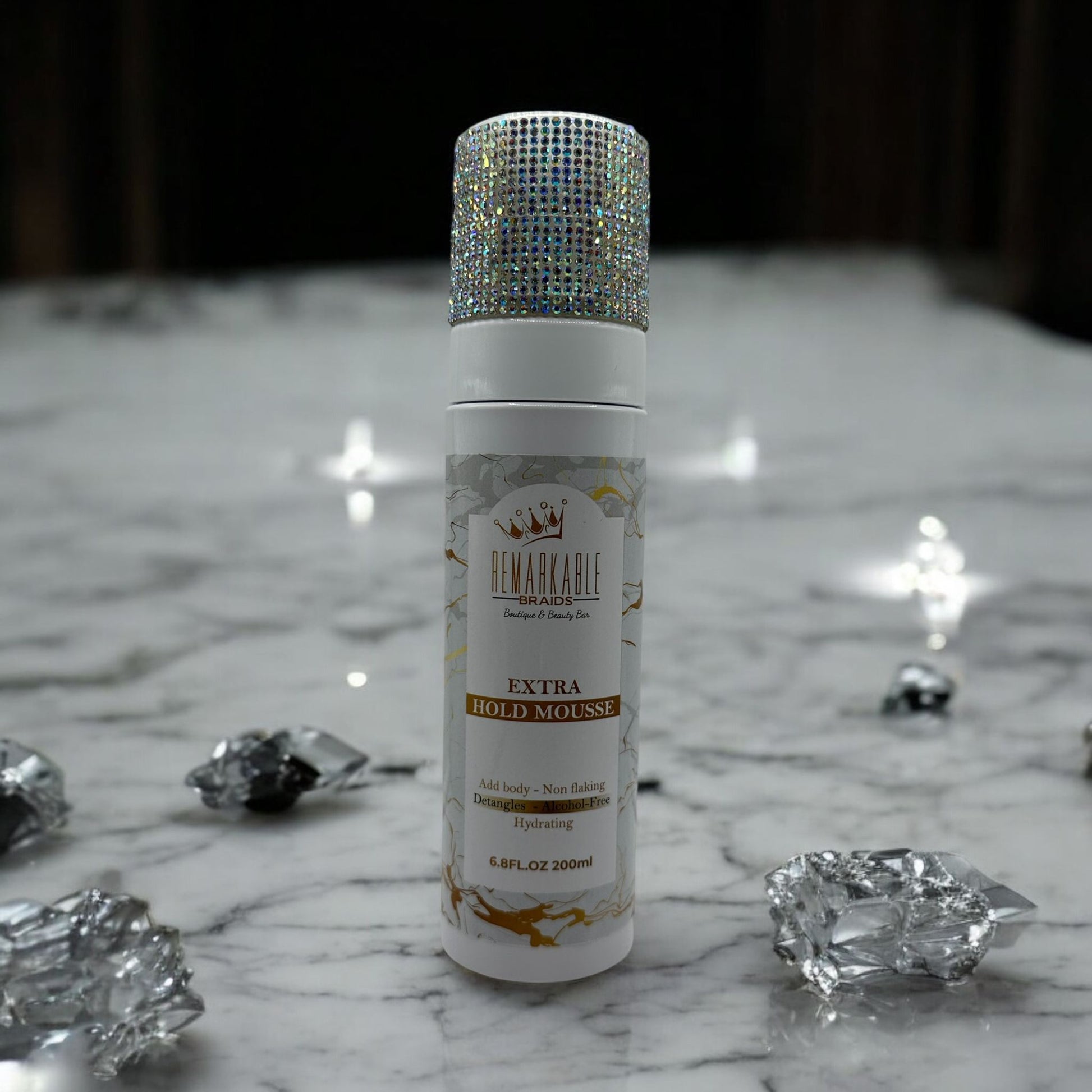 Remarkable Extra Hold Hair Mousse bottle with decorative cap on a marble surface with crystals